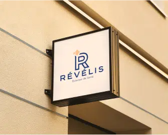 Une plaque au mur avec le logo du centres d imagerie medicale Revelis | Groupe Revelis
