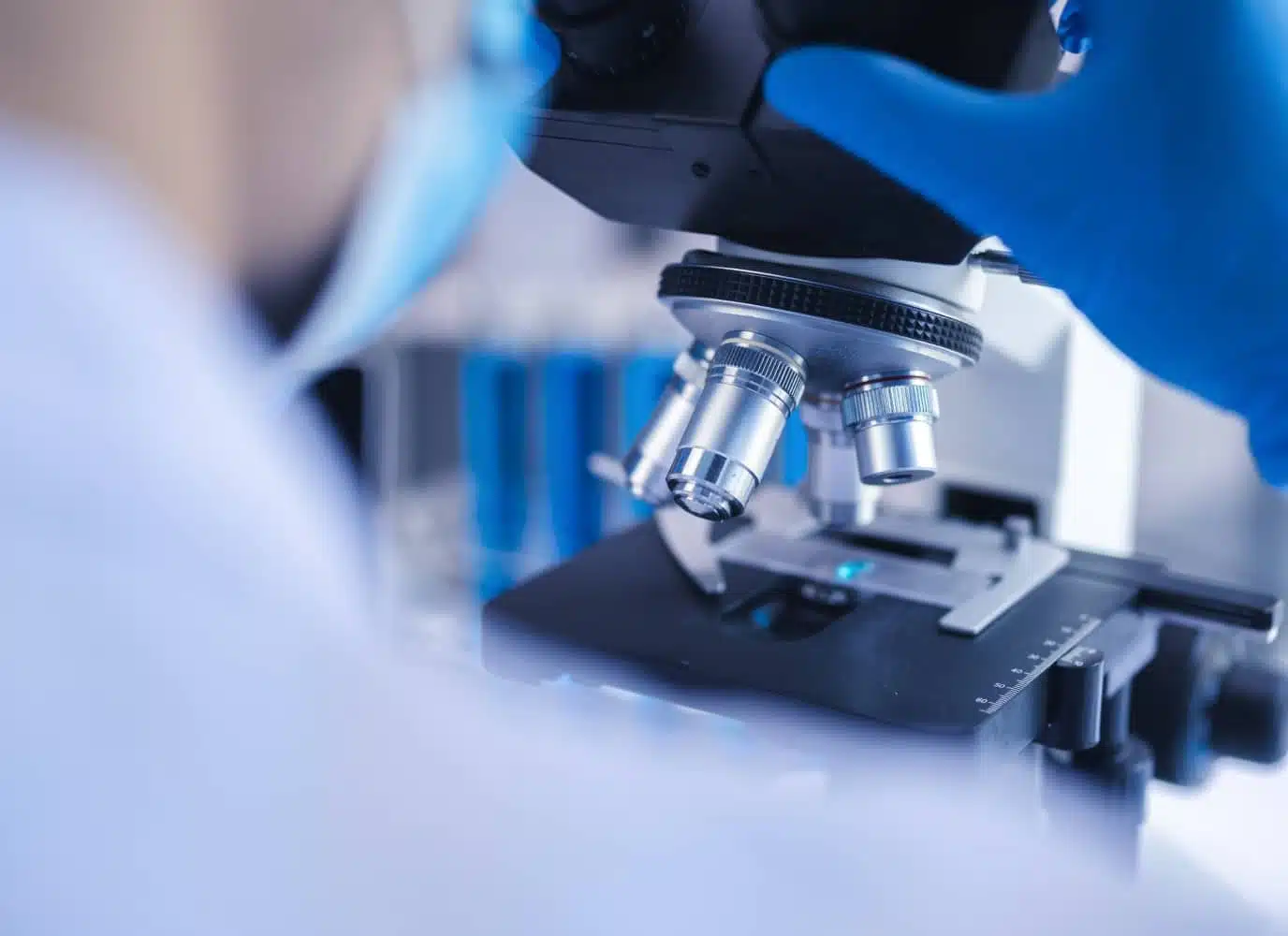 Medecin regardant dans un microscope Biopsies en radiologie interventionnelle | Groupe Revelis